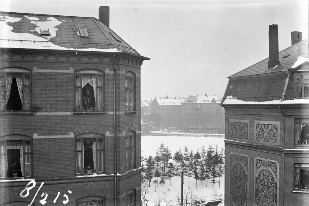 14183.1.5 Billedet er taget fra N.J. Fjords Allé 4, 1957 Frederiksberg C, 8.2. 1915 med kig mellem nr. 3 og 5 til den daværende jernbaneoverskæring på Bülowsvej. Egen FB 9.10.2023