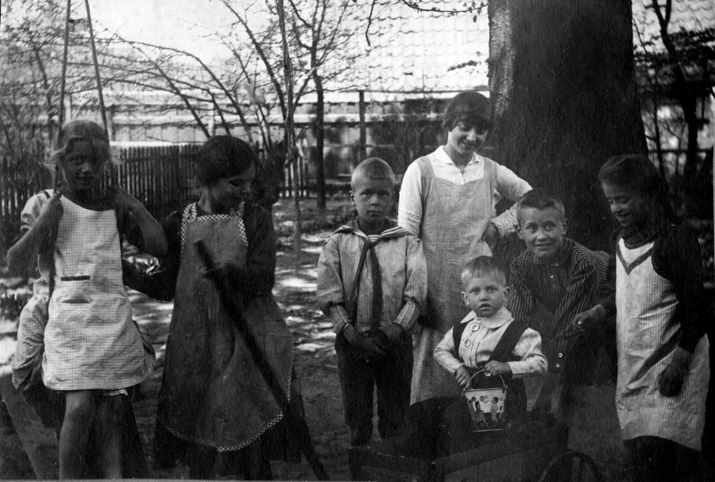 71.95 Fra haven i Helsingør. Kapt. Gerts børn og vore. Pigen der holder trækstangen er Lull, drengen med spanden er Per Sletting og pigen længst til højre er Lene Sletting.