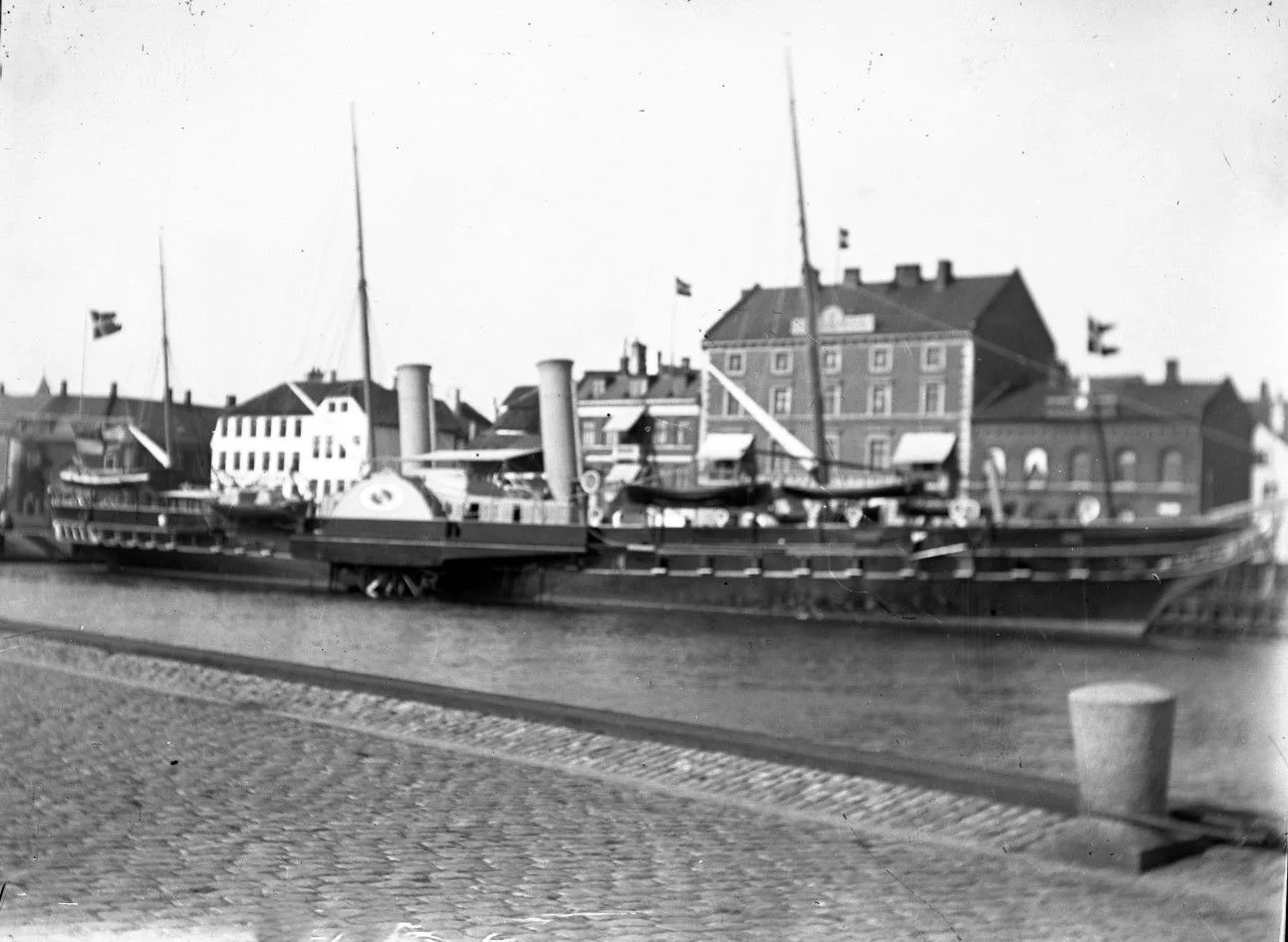 14485.8 Det højeste hus er Jernbanehotellet, der brændte i marts 1938. I årene 1939 og 1940 rev man alle husene ned. Stedet er i dag en stor P-plads.