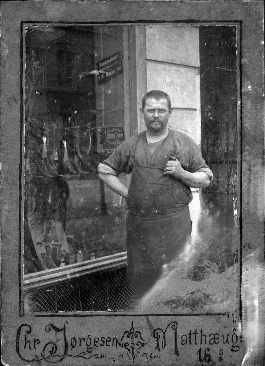 14535.1 Fotografen Chr. Jørgensen, Matthæusgade 16, 3. - Det er sikkert en amatørfotograf der selv har malet billedets baggrund. Skomageren er ukendt.