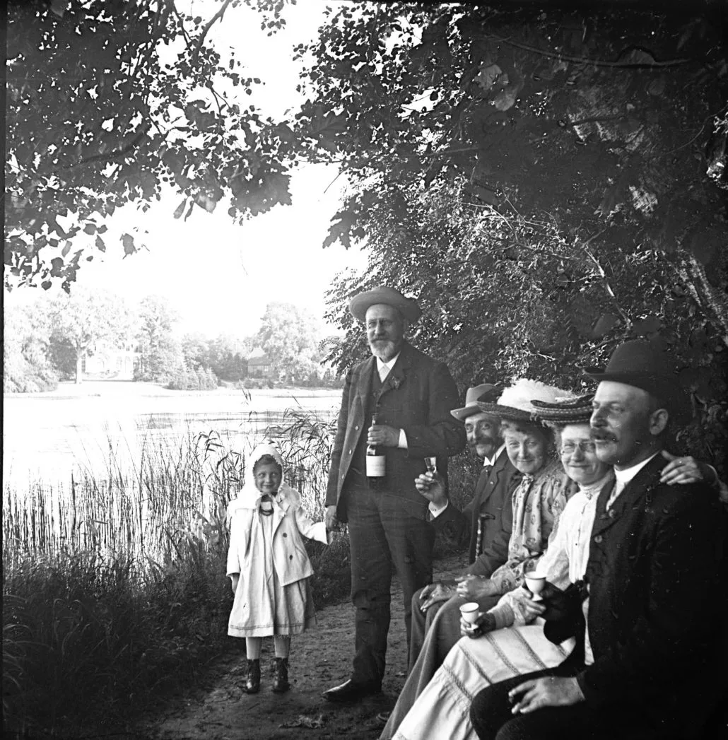 90.219 Hjalmar og Estre Alstrup i selskab med feststemte mennesker ved sø.