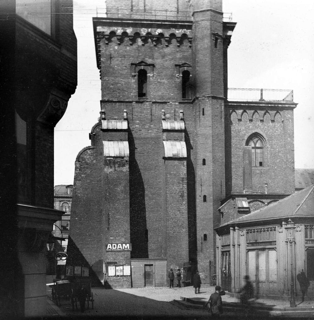 90.385 Det er Nikolaj Taarn set fra hjørnet af Fortunstræde og Admiralgade. Til højre ses lidt af Slagterboderne på Nikolaj Plads.